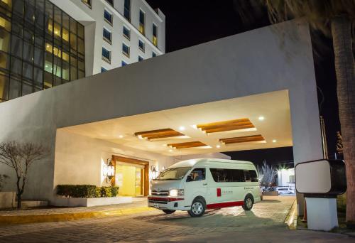 a white van parked in front of a building at Fiesta Inn Ciudad Juarez in Ciudad Juárez