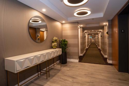 a hallway with a mirror and a long corridor at Sandman Hotel Hamilton in Hamilton