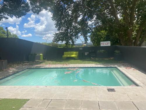 a swimming pool in a yard with a fence at Lovely Rosebank 1-bedroom condo with pool & cinema in Johannesburg
