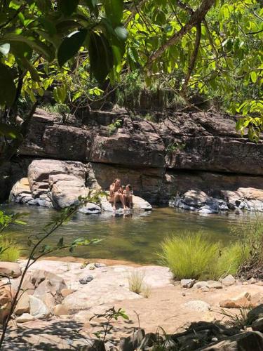 two people sitting in a pool of water at Chalé na Chapada, com acesso ao Rio São Miguel in Sao Jorge