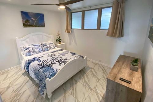 a bedroom with a bed with a blue and white comforter at High-End Resort Condo Nestled on Molokai Shoreline in Kaunakakai