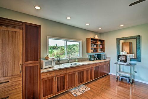 a kitchen with a counter with a sink and a window at The Aloha Green House Retreat with Ocean Views! in Naalehu