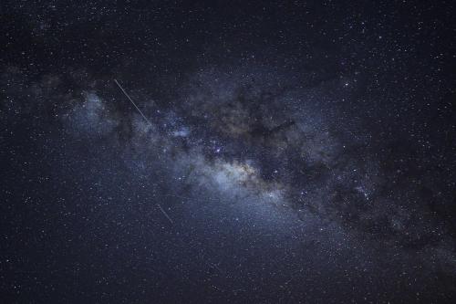 a milky way galaxy at night with a plane at The Aloha Green House Retreat with Ocean Views! in Naalehu