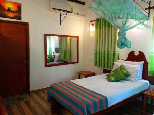 a bedroom with a bed and a mirror at Hideaway Homestay Habarana in Habarana