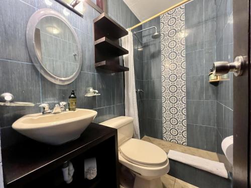 a bathroom with a sink and a toilet and a mirror at Palmazul Hotel & Spa in San Clemente