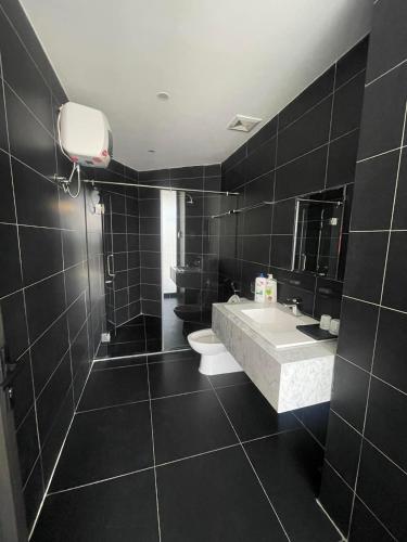 a black bathroom with a toilet and a sink at Panorama Apartment in Da Lat
