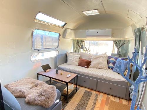 a caravan living room with a couch and a table at アンカービレッジ九十九里 in Hasunuma