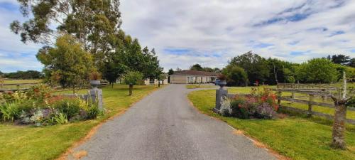 a gravel road leading to a house on a farm at 64 Mandalea B&B in Ohoka