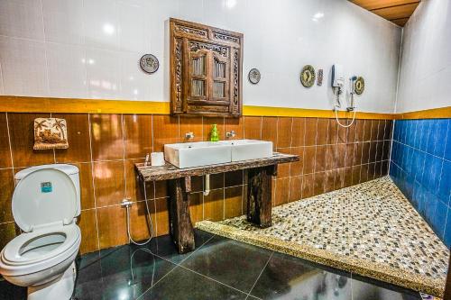 a bathroom with a toilet and a sink at Lost Paradise Resort in Batu Ferringhi