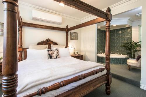 a bedroom with a four poster bed and a bath tub at Moulton Park Estate - Cottages in Sassafras