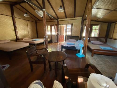 Zimmer mit mehreren Betten sowie einem Tisch und Stühlen in der Unterkunft No. 8 Pai in Pai