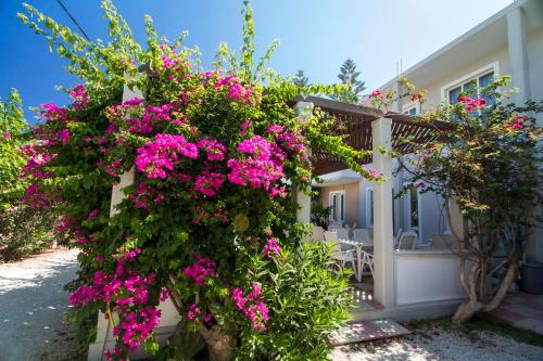 a house with pink flowers on the side of it at Hotel Peli in Kissamos