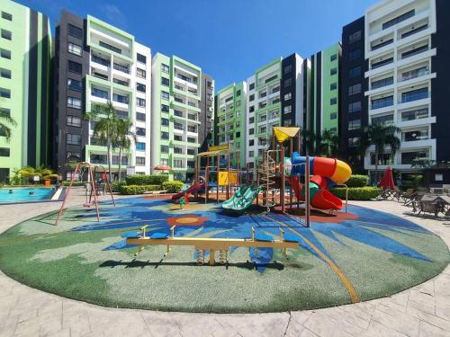 un parque infantil frente a un complejo de apartamentos con edificios en Manhattan Condo Ipoh with Water Park and Pool View, en Ipoh