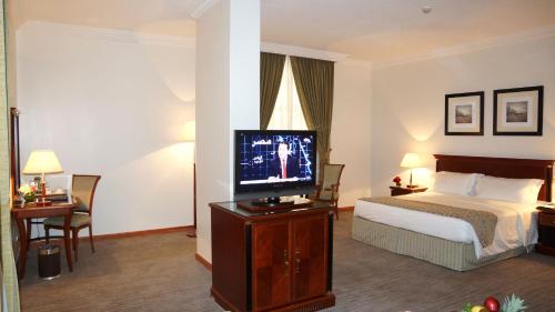 a hotel room with a bed and a flat screen tv at Executives Hotel - Olaya in Riyadh