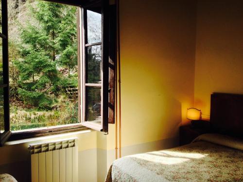 a bedroom with a bed and a window at Locanda Dei Baroni - Antica Dimora in Camaldoli