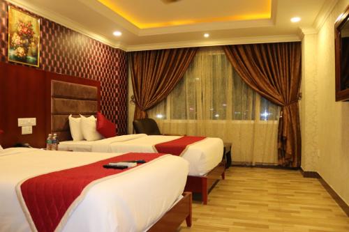 a hotel room with two beds and a window at Hyders Park The Business Hotel in Thanjāvūr