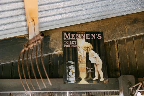 a shelf with a book and a statue of a man holding a beer at Mintaro Hideaway in Mintaro