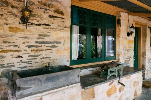 a stone house with a window and a bench at Mintaro Hideaway in Mintaro