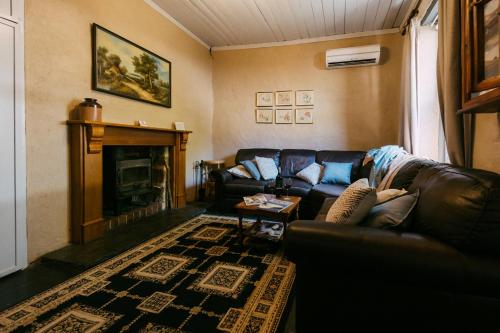 a living room with a couch and a fireplace at Mintaro Hideaway in Mintaro