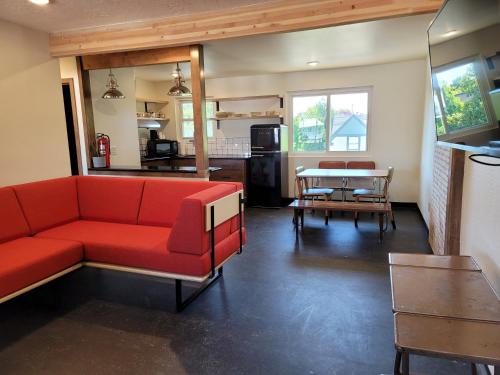 a living room with a red couch and a table at Hotel Corvallis in Corvallis
