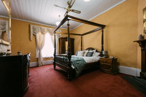 a bedroom with a canopy bed and a window at Mintaro Hideaway in Mintaro