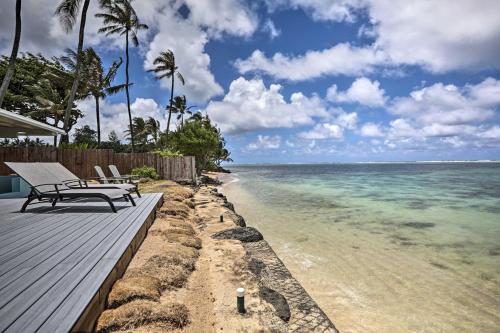 a bench sitting on a wooden deck next to the ocean at WFH in Paradise Beachfront Hauula Getaway! in Laie