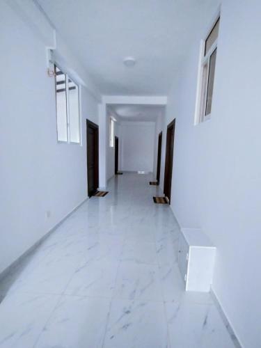 an empty hallway with white walls and white tile floors at Bivon Reach in Uswetakeiyawa