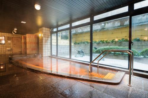 a empty room with a bench in front of a window at Kanazawa Hakuchoro Hotel Sanraku -Natural Hot Spring- in Kanazawa