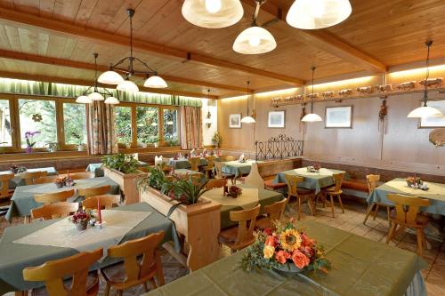 a restaurant with tables and chairs in a room at Gasthof Pension Berghof in Hippach