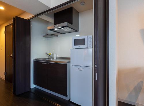 a small kitchen with a refrigerator and a microwave at VACATION INN HEIWAJIMA 1 - Vacation STAY 10876 in Tokyo