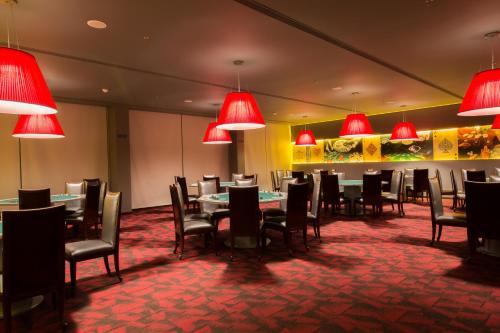a dining room with tables and chairs and red lamps at Iscon The Fern Resort & Spa, Bhavnagar in Bhavnagar