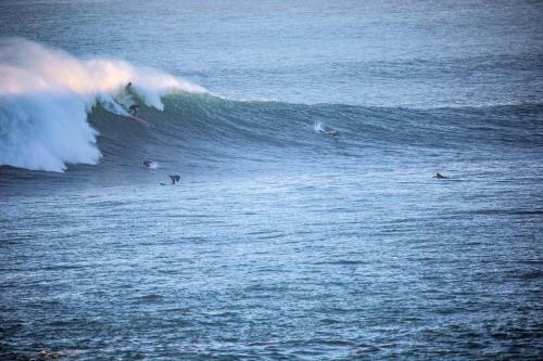 a group of surfers riding a wave in the ocean at Mobil Home Saint Paul lès Dax in Saint-Paul-lès-Dax