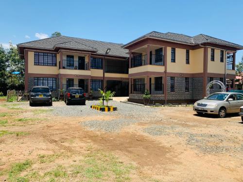 uma casa grande com carros estacionados em frente em Yonga Apartment em Kisumu