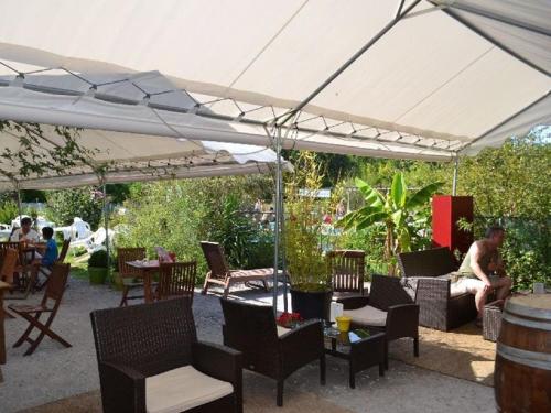 a white canopy over a patio with chairs and tables at Mobil Home Saint Paul lès Dax in Saint-Paul-lès-Dax