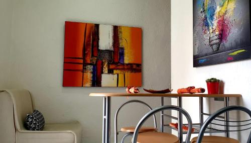a table with two chairs and a painting on the wall at Vima's home in Naples