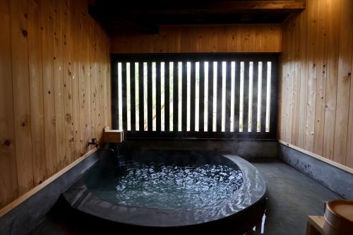 a jacuzzi tub in a wooden room at kominka neri（古民家煉り） in Miyawaka