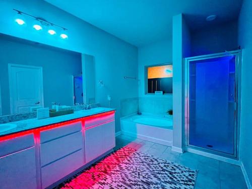 a bathroom with blue and red lighting and a shower at Varona's Paradise: Stunning New Luxury Home. in Lake Charles