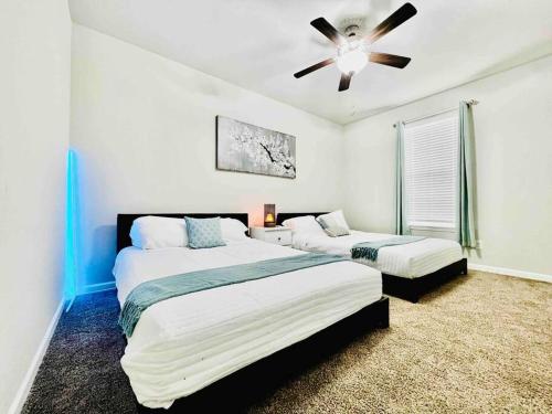a bedroom with two beds and a ceiling fan at Varona's Paradise: Stunning New Luxury Home. in Lake Charles