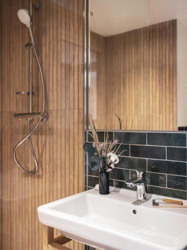 a bathroom with a white sink and a shower at La Belle Ville in Paris