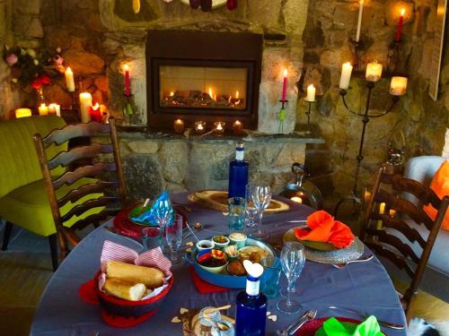 een tafel met eten en een open haard in een kamer bij Lower Barns Guest House in Mevagissey