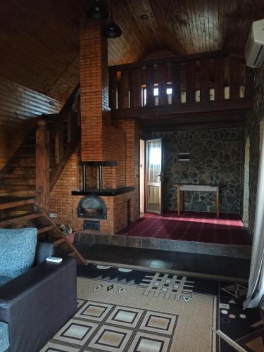 sala de estar con escalera y chimenea en La Boier en Bălţi