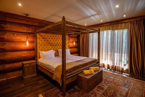 a bedroom with a canopy bed and a window at Alpina Luxury Chalets in Banya