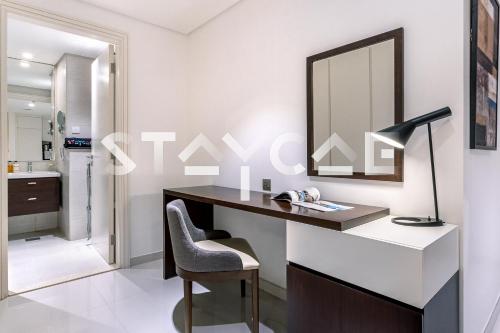 uma secretária com um espelho e uma cadeira na casa de banho em Staycae Avanti em Dubai