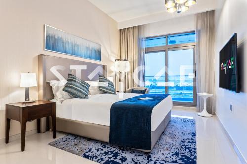 um quarto com uma cama grande e uma janela grande em Staycae Avanti em Dubai