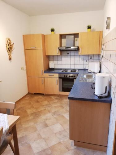 a kitchen with wooden cabinets and a blue counter top at Ferienwohnung Kroeschell in Bad Sachsa