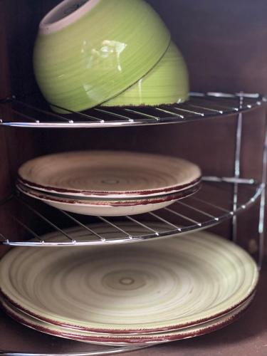 three plates and a vase sitting on a shelf at Berlin entspannt geniessen in Berlin
