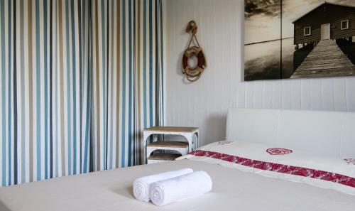 a bedroom with a bed with two towels on it at Case Li Conchi Sardegna in Castiadas