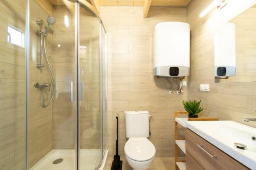 a bathroom with a shower and a toilet and a sink at Domki Heyne Holiday in Ustka