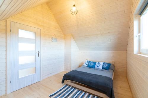 ウストカにあるDomki Heyne Holidayのベッドと窓が備わる小さな客室です。