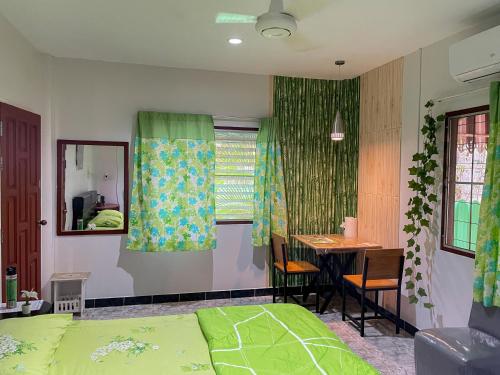 1 dormitorio con cama, mesa y escritorio en H&Q Bangtao Rooms en Bang Tao Beach